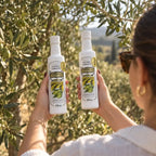 Mulher segurando duas garrafas de Azeite Extra Virgem Prosperato Premium 250 mL diante de uma oliveira carregada, mostrando o rótulo com o selo "Nº 1 Brasil" e o blend Arbequina Arbosana.