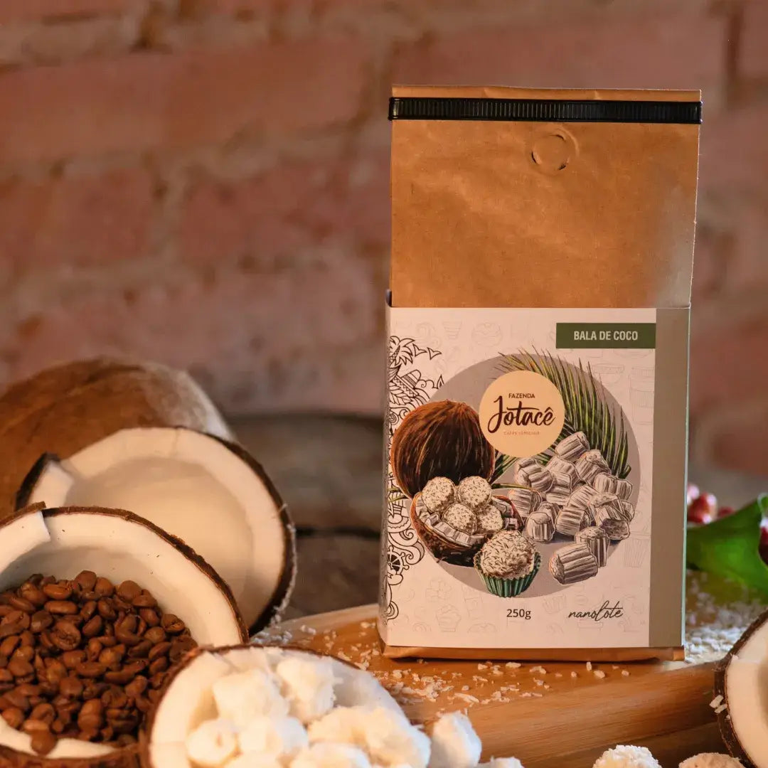 Café Bala de Coco da Fazenda Jotacê exposto ao lado de grãos de café e pedaços de coco, evidenciando os aromas e sabores naturais do produto.