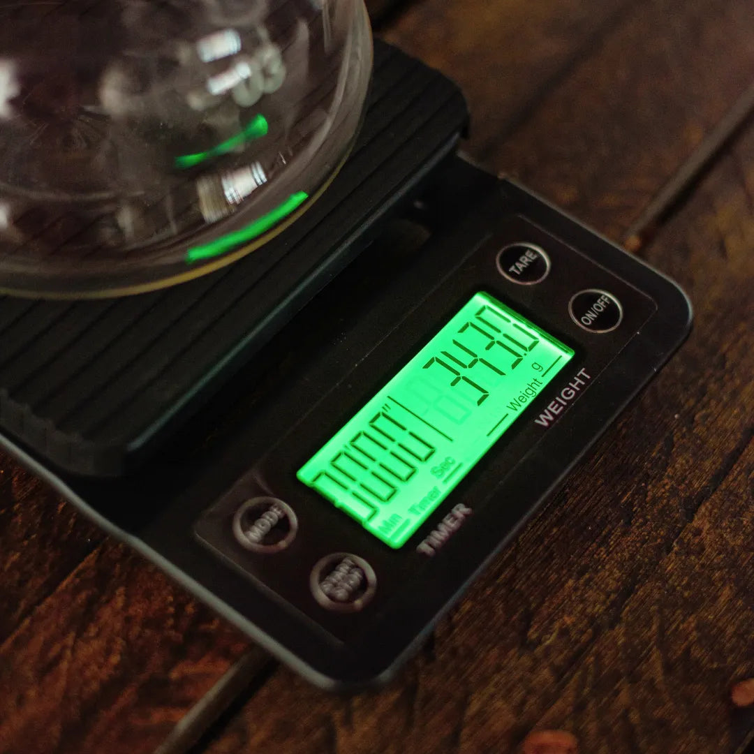  display da balança digital black da mimo style em funcionamento medindo a massa de líquido contido em uma jarra de vidro