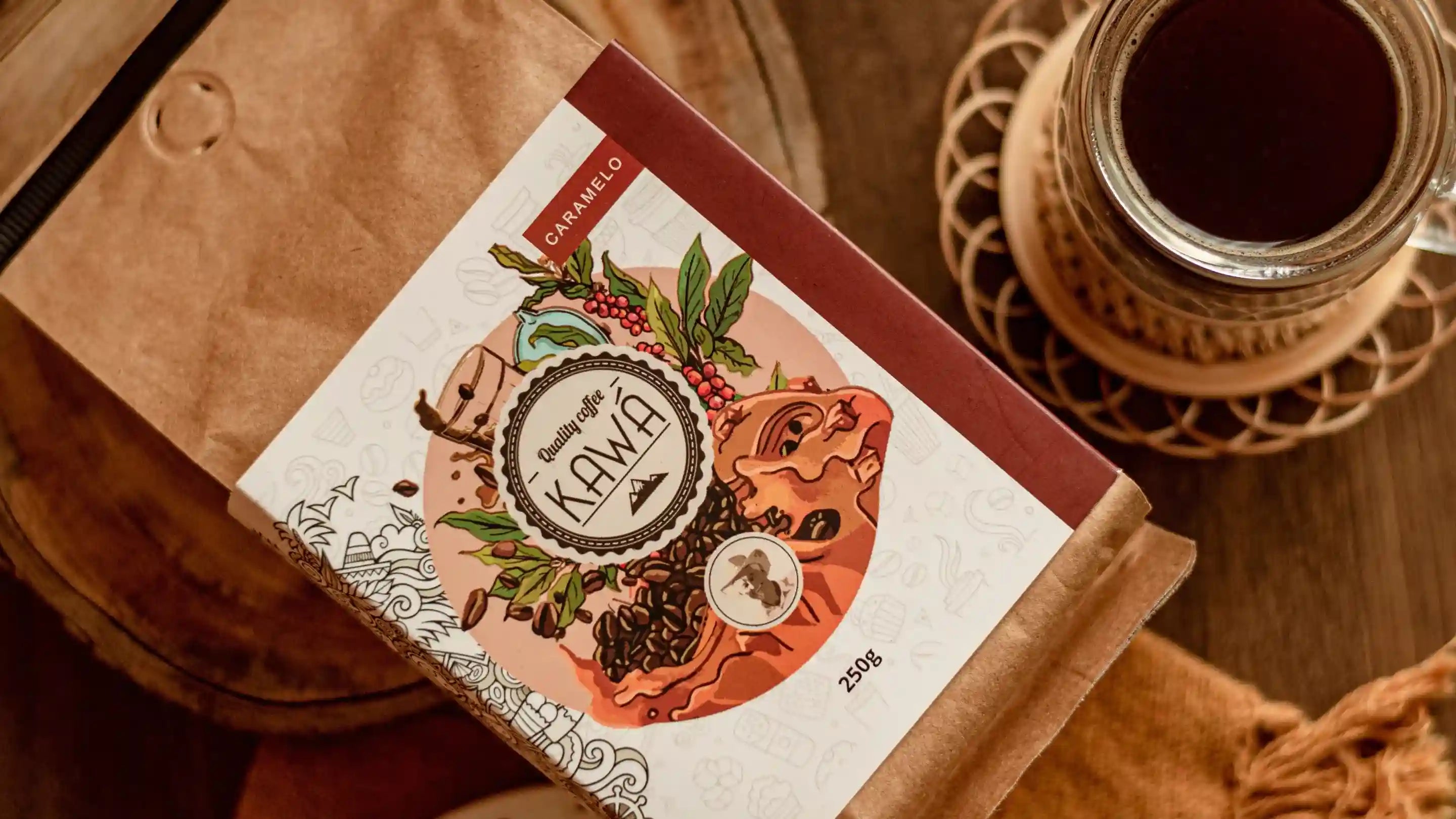 um pacote de café especial kawá caramelo ao lado de uma xícara de café sobre uma mesa de madeira