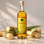 Garrafa de cachaça amarela entre pedaços de cana-de-açúcar cortada