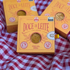 Caixas de doce de leite com ameixa sobre toalha xadrez, embalagem presente estilo gaveta.