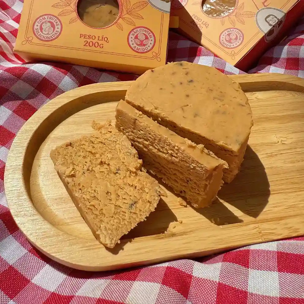 Doce de leite de corte com ameixa fatiado em tábua, mostrando textura cremosa.