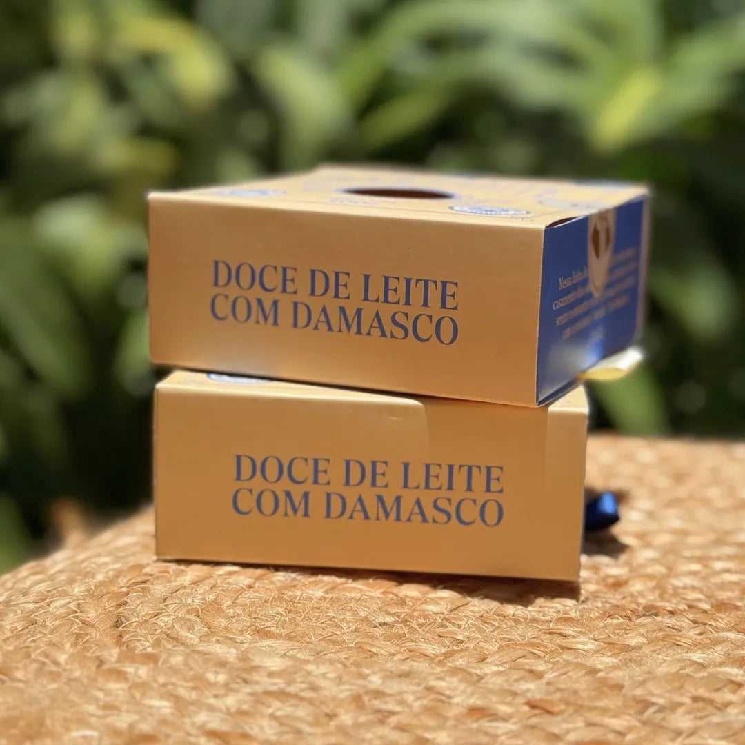 Vista lateral de caixas empilhadas de doce de leite de corte com damasco em embalagem para presente.