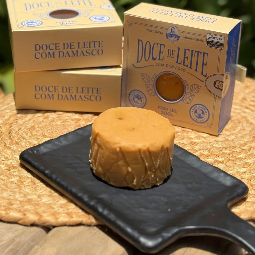 Pedaço inteiro de doce de leite de corte com damasco sobre tábua.
