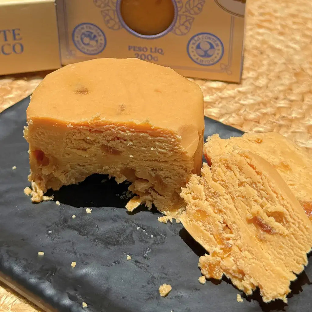 Pedaços de doce de leite com damasco ao lado da caixa presente estilo gaveta.