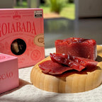 Goiabada cascão artesanal cortada em fatias grossas, com textura firme e brilho natural, posicionada sobre base de madeira.