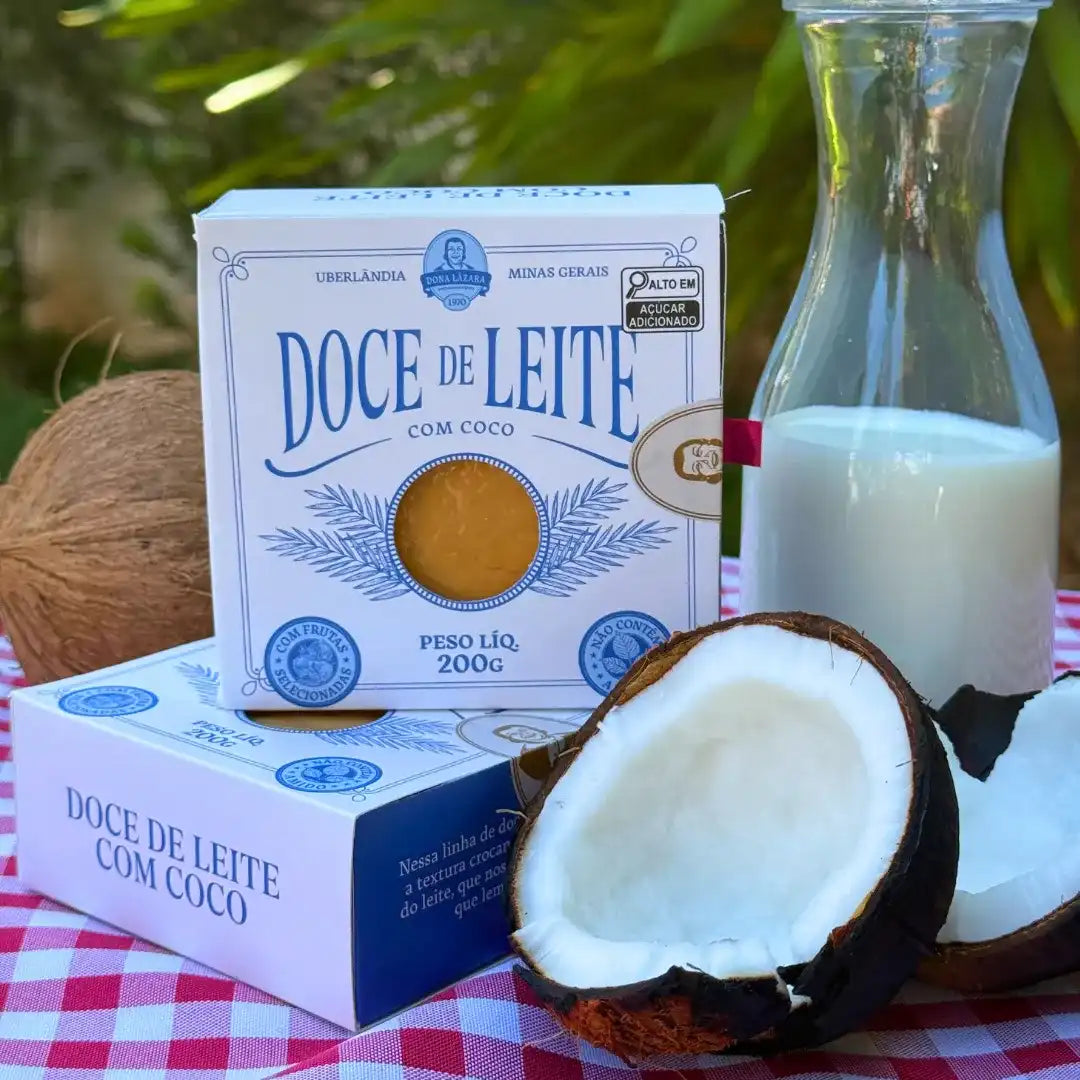 Cena com coco aberto, garrafa de leite e a caixa de Doce de Leite com Coco Dona Lázara sobre toalha xadrez vermelha, evocando o clima da fazenda e tradição mineira.