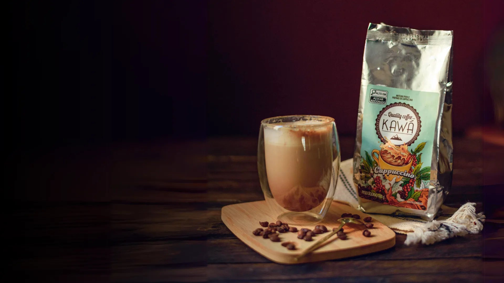 Pacote do Cappuccino Especial Kawá ao lado de um cappuccino cremoso em um copo transparente