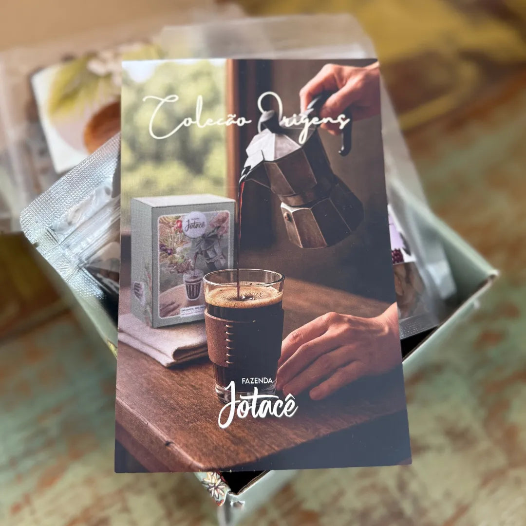 Detalhes do Flyer que acompanha a Coleção Origens da Fazenda Jotacê sobre mesa de madeira