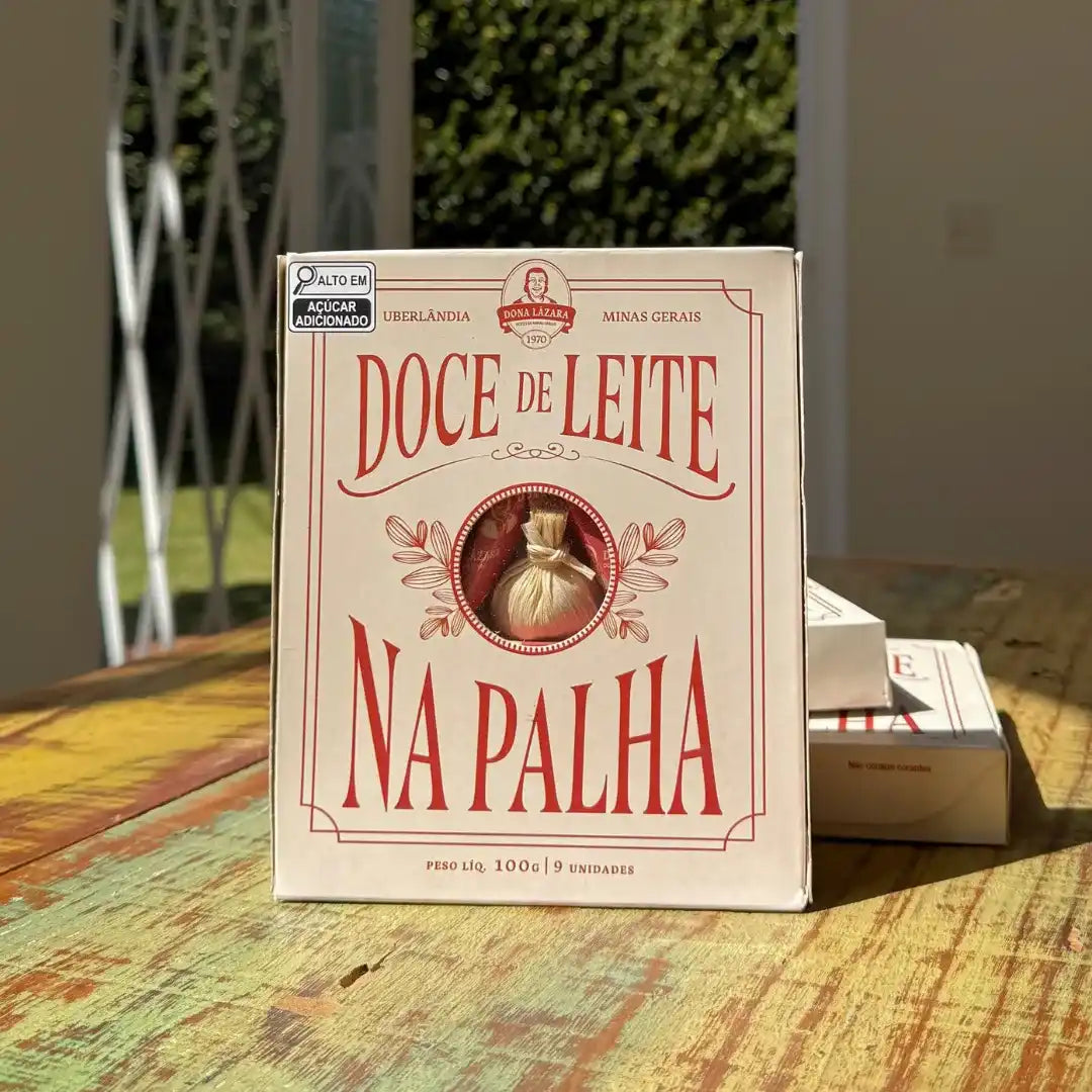 Caixa de Doce de Leite na Palha Dona Lázara posicionada em ambiente iluminado, evidenciando o design retrô e a janela que mostra o doce na palha.
