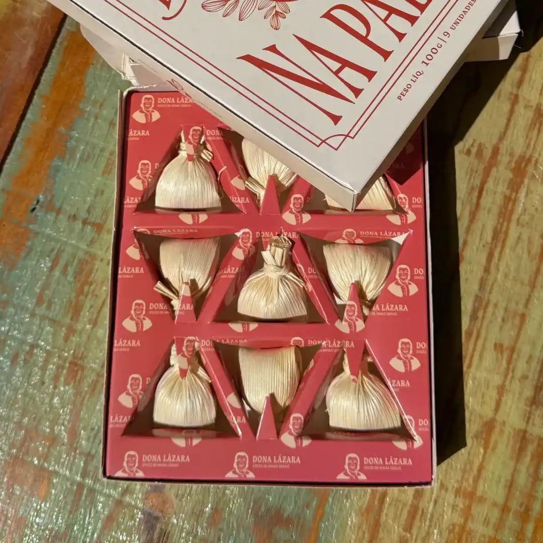 Visão superior da caixa de Doce de Leite na Palha aberta, revelando as unidades perfeitamente organizadas no berço de apresentação vermelho.