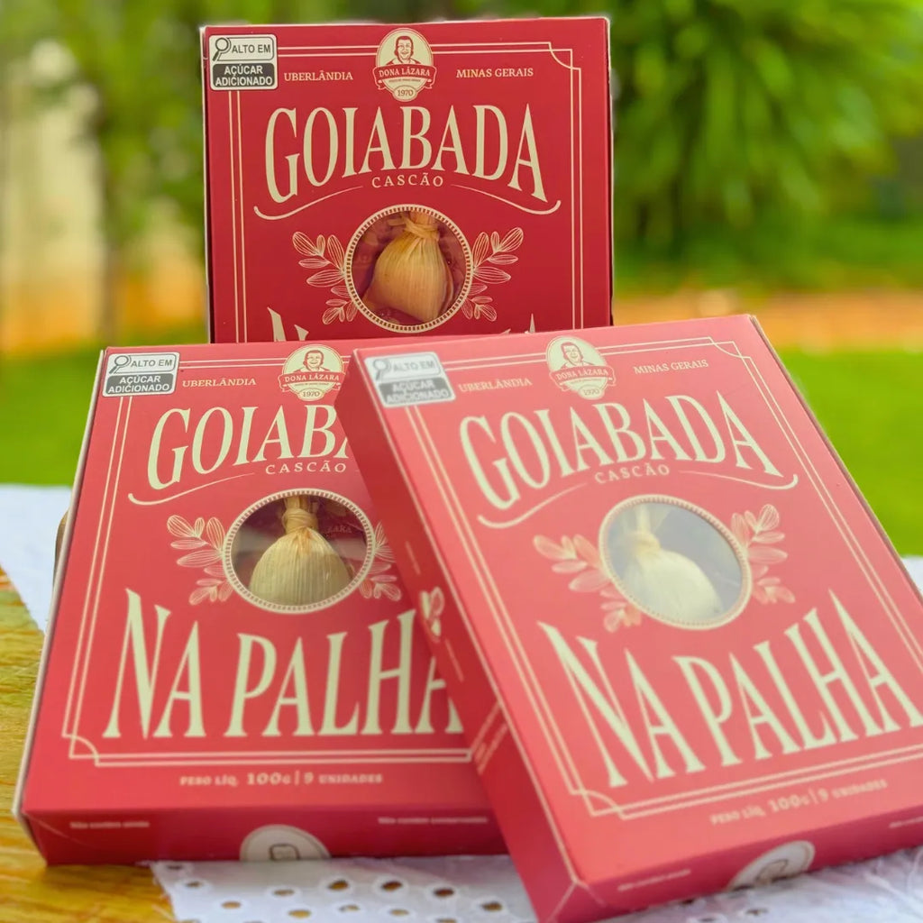 Três caixas vermelhas de Goiabada Cascão na Palha Dona Lázara empilhadas em cenário de jardim, com visor circular no centro mostrando doce em palha de milho, marca de Uberlândia MG