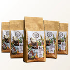 5 pacotes em pé de 1 Kg do Kawá Caramelo da Fazenda Jotacê, dispostos em formação triangular com fundo branco