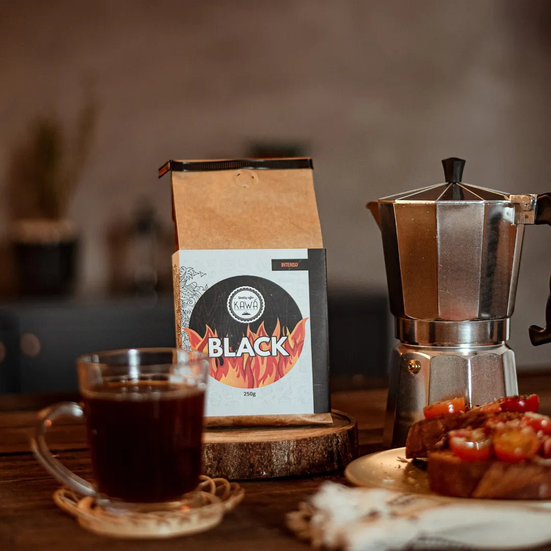 Café Kawá Black ao lado de cafeteira italiana e em sua frente uma xícara de café e bruschetas