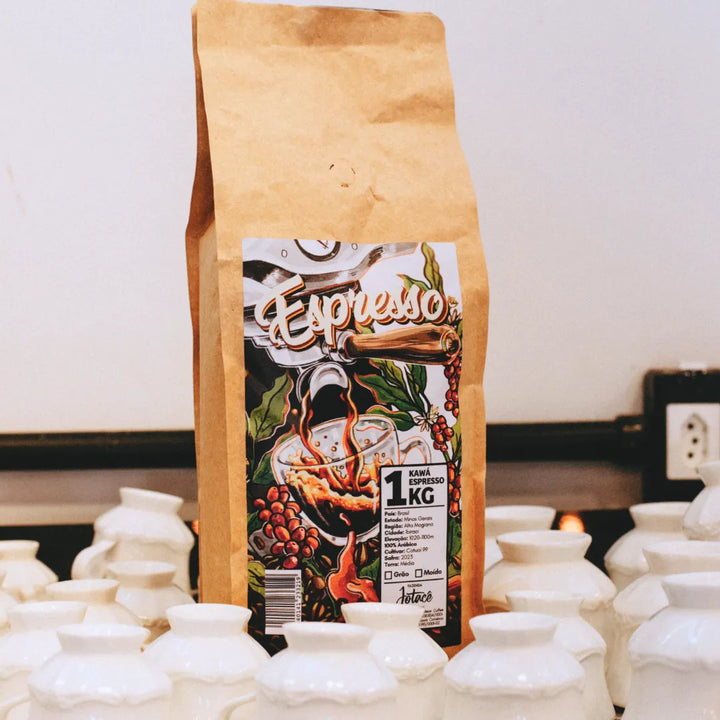 Pacote de café Kawá Espresso sobre balcão com xícaras brancas ao fundo