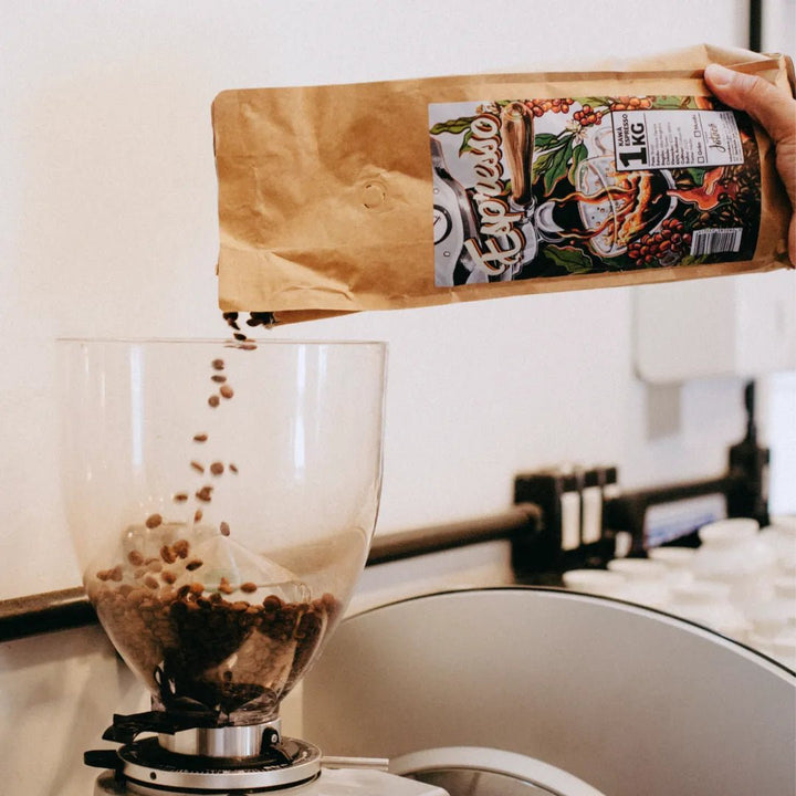 Grãos de Kawá Espresso Sendo despejados em um moinho