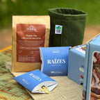 Composição da Coleção Raízes com duas pillow boxes — uma aberta mostrando as sementes de café arábica verdes — terra TERRAL, vaso King Pot e caixa do kit de plantio.
