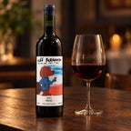 Garrafa de vinho merlot seco Cão Perdigueiro e taça sobre mesa de madeira, em ambiente à luz de velas